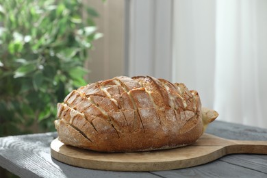 Photo of Freshly baked bread with tofu cheese on grey wooden table indoors