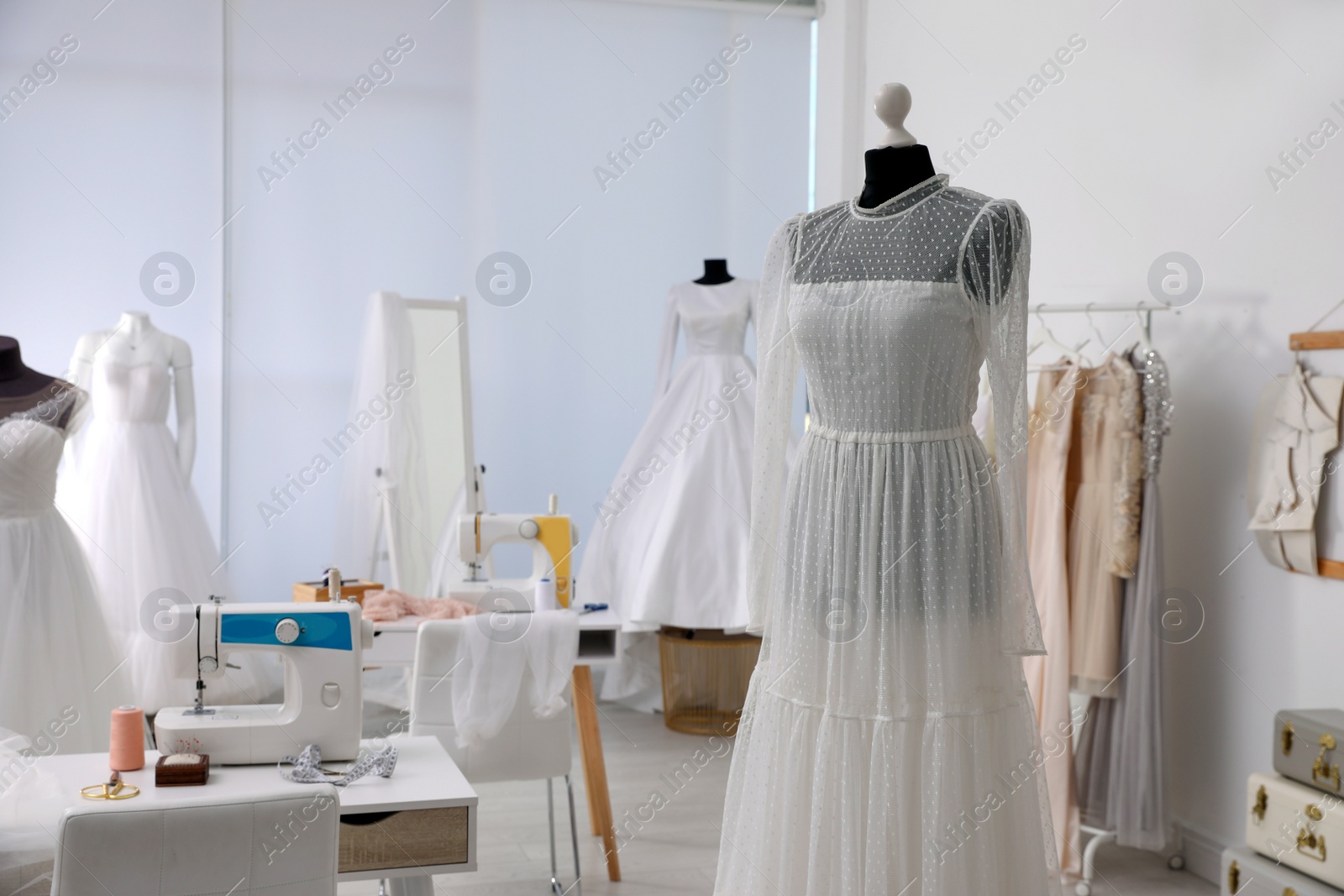 Photo of Mannequin with beautiful wedding dress in atelier