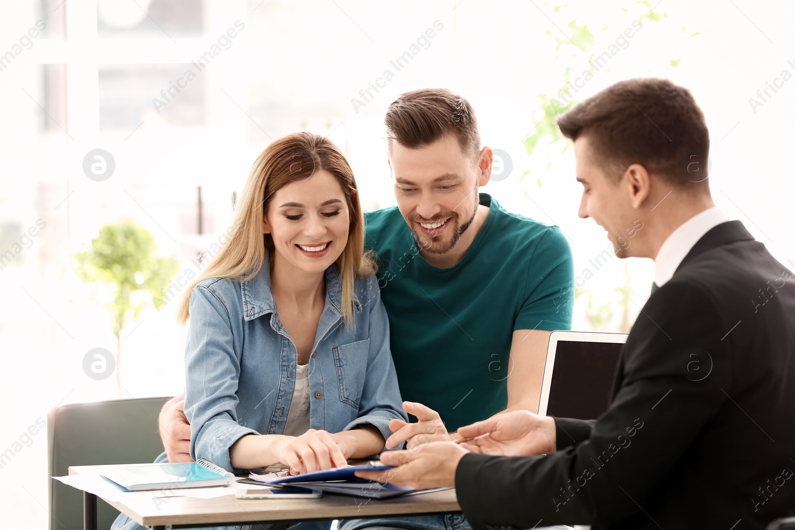 Photo of Young couple meeting with consultant in office