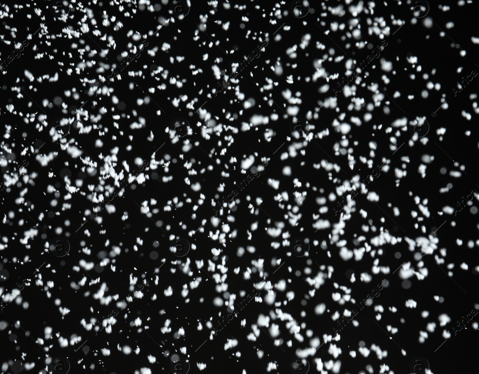 Photo of White snow falling down on black background