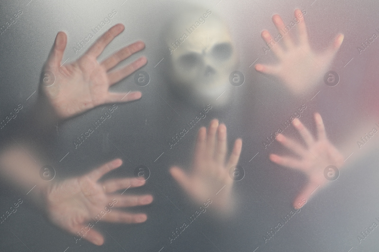 Photo of Silhouette of creepy ghost with skull behind cloth