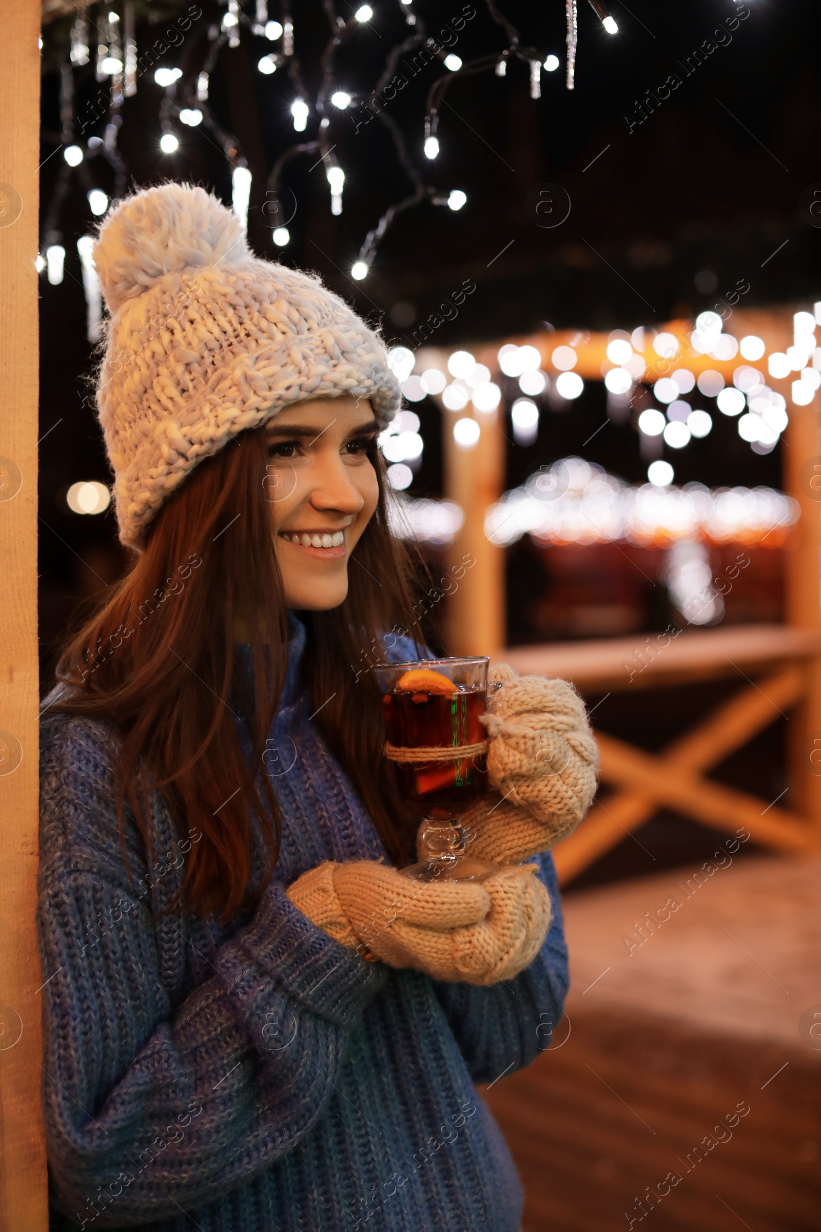 Photo of Woman with glass cup of mulled wine at winter fair