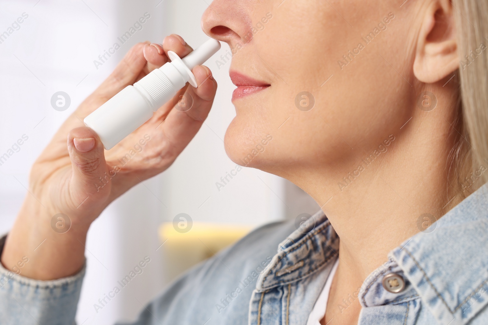 Photo of Medical drops. Woman using nasal spray indoors, closeup