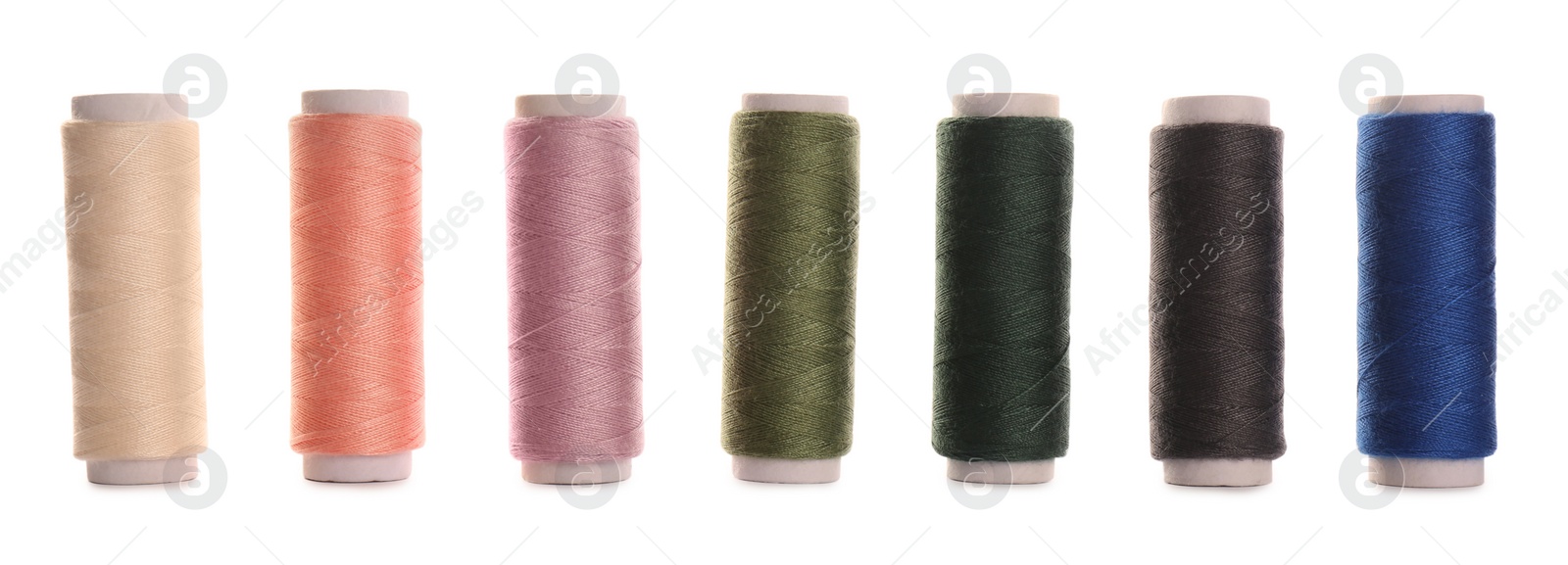 Photo of Set of colorful sewing threads on white background