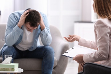 Photo of Psychotherapist working with young man in office