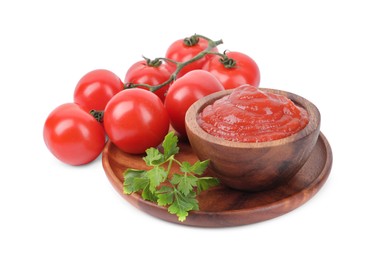 Photo of Organic ketchup in bowl, fresh tomatoes and parsley isolated on white. Tomato sauce