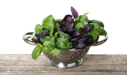 Photo of Metal colander with fresh basil leaves on wooden table against white background