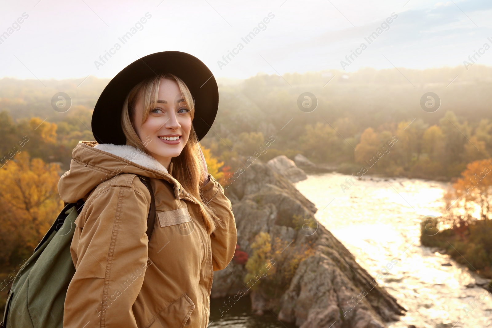 Photo of Woman with backpack enjoying beautiful view near mountain river