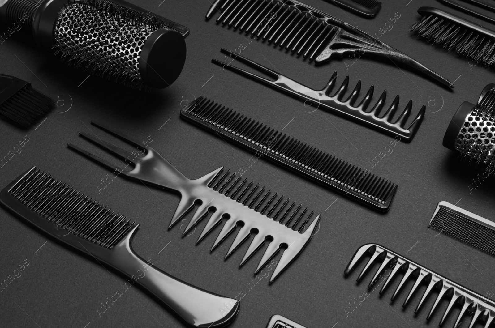 Photo of Composition with modern hair combs and brushes on black background