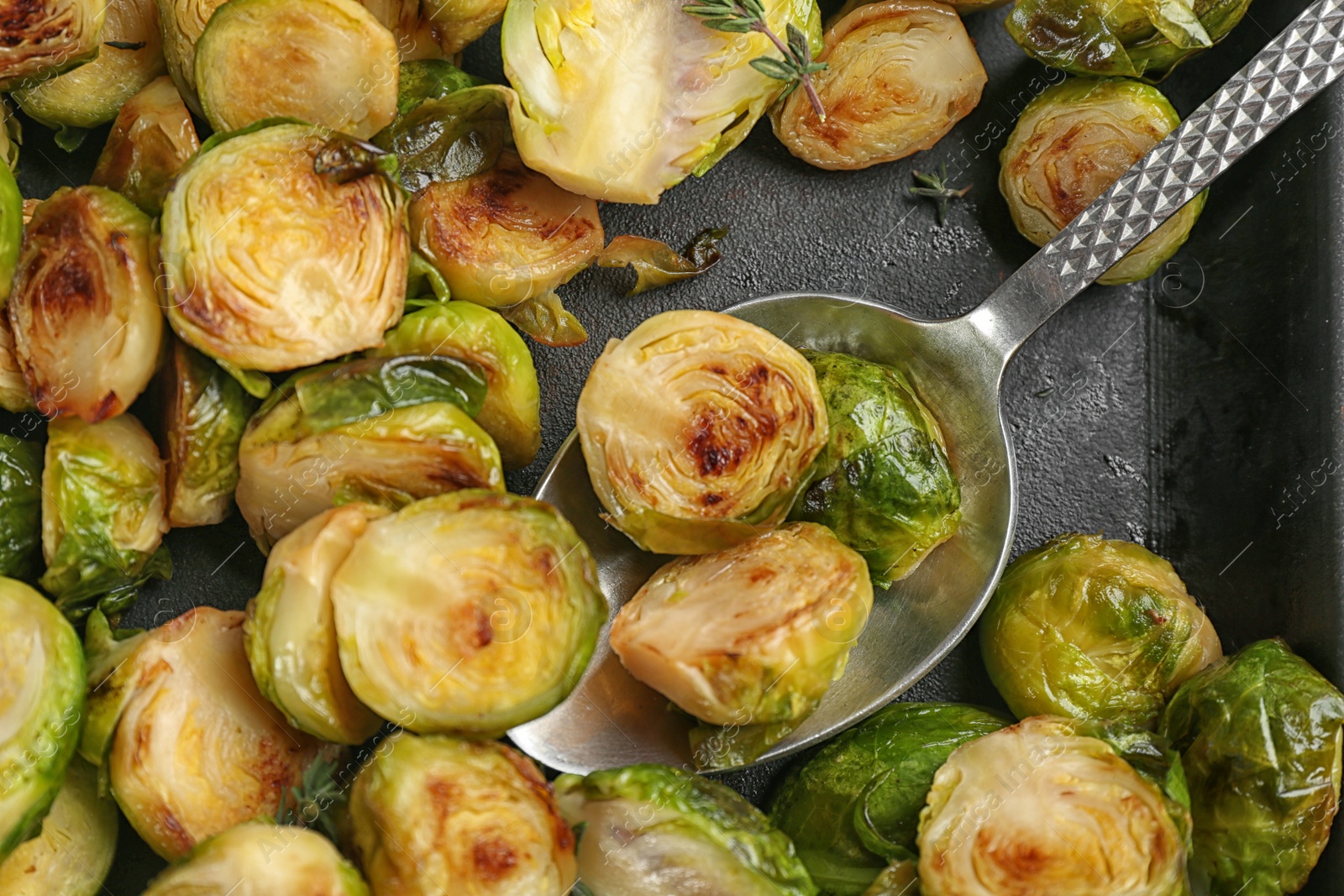 Photo of Delicious roasted brussels sprouts in baking dish, closeup