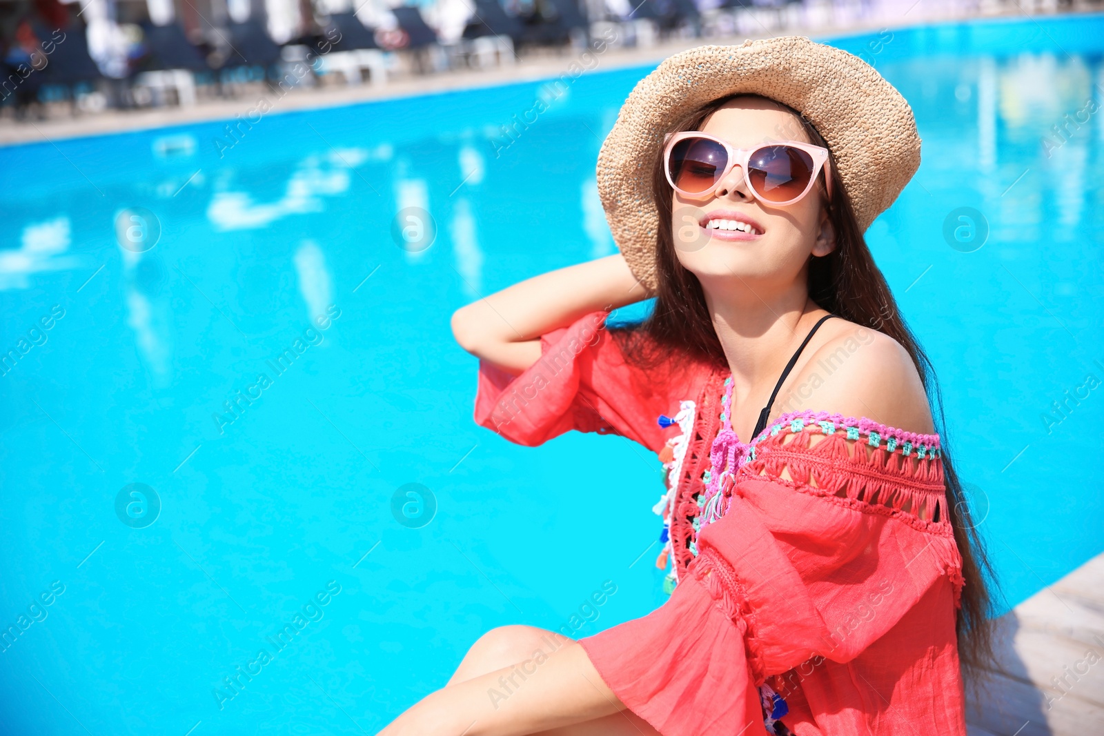 Photo of Beautiful young woman posing near swimming pool