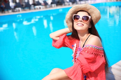 Photo of Beautiful young woman posing near swimming pool