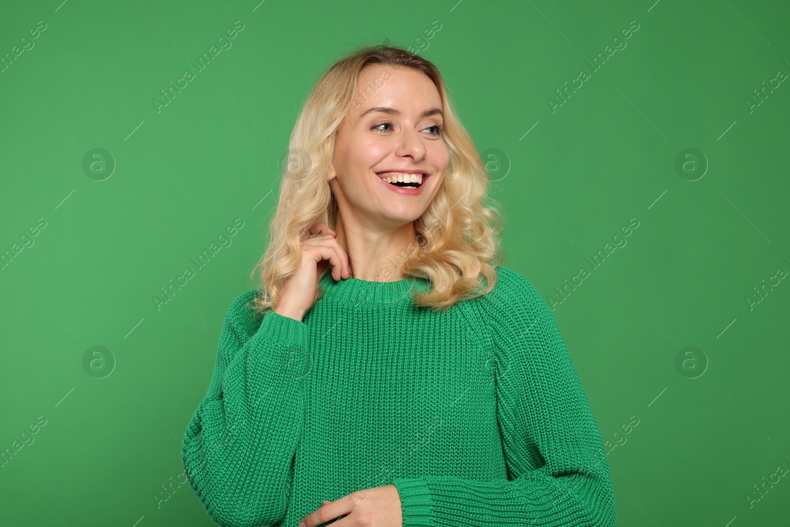 Photo of Happy woman in stylish warm sweater on green background