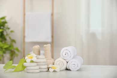 Photo of Composition with different spa products and plumeria flowers on white marble table indoors, space for text