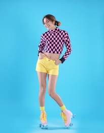 Photo of Young woman with retro roller skates on color background