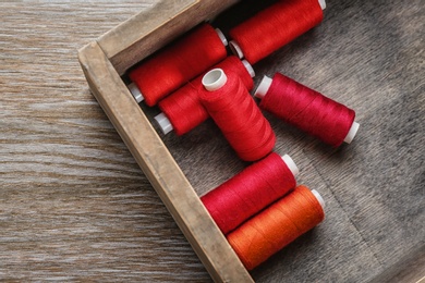 Wooden box with color sewing threads, closeup