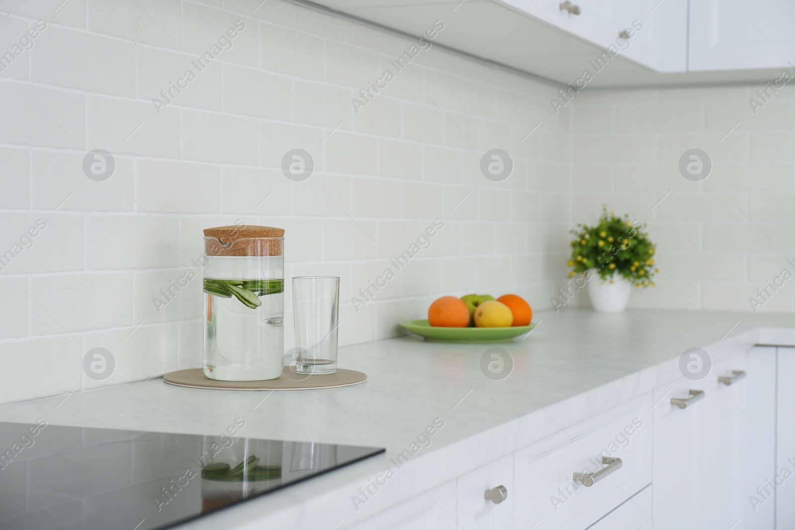 Photo of Drink, fruits and houseplant on counter in kitchen. Interior design