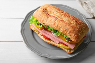 Tasty sandwich with boiled sausage, cheese and vegetables on white wooden table, closeup