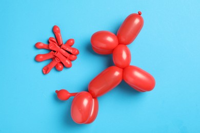 Dog figure made of modelling balloon on light blue background, flat lay