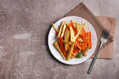 Plate with tasty parsnip and bell pepper served on brown textured table, flat lay. Space for text