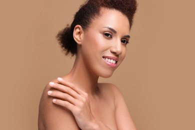 Photo of Portrait of beautiful young woman with glamorous makeup on light brown background