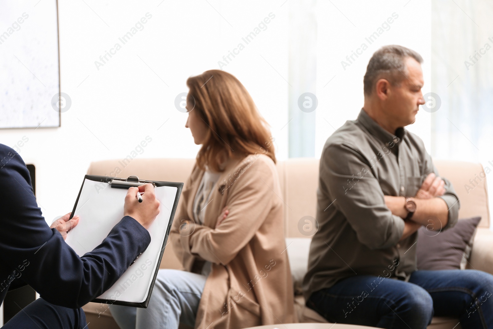 Photo of Psychotherapist working with couple in office. Family counselling