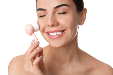 Photo of Young woman using facial cleansing brush on white background. Washing accessory