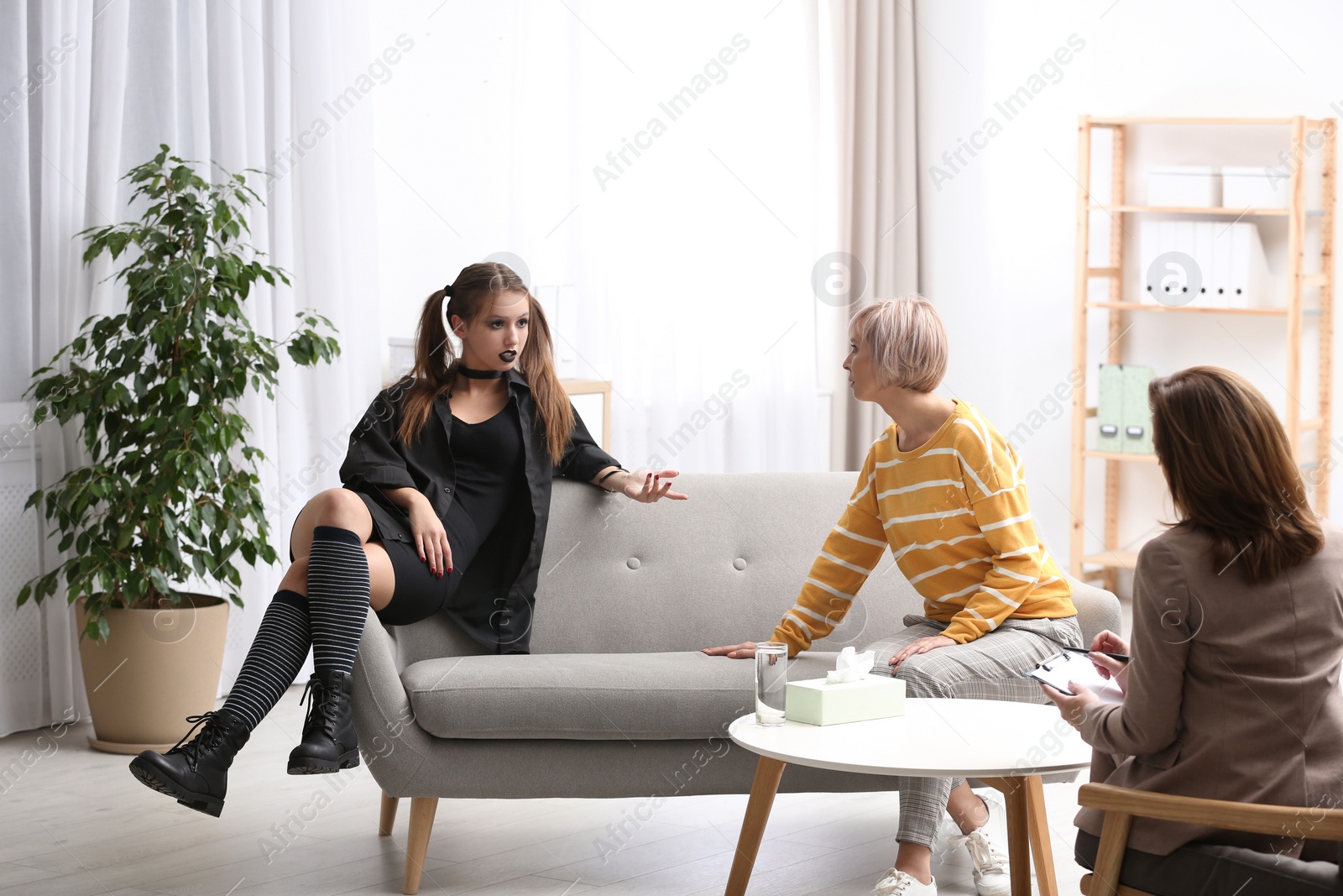 Photo of Psychotherapist working with teenage goth girl and her mother in office