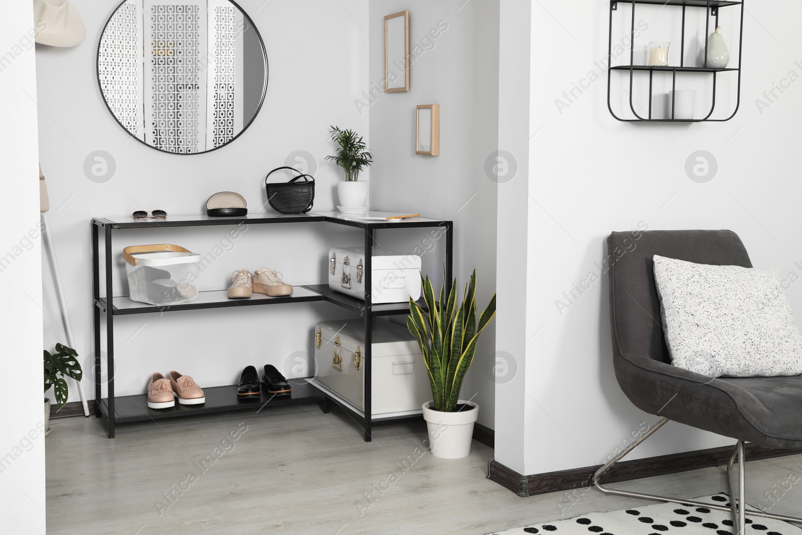 Photo of Hallway interior with stylish furniture and round mirror on light wall