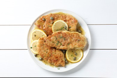 Photo of Delicious chicken piccata on white wooden table, top view