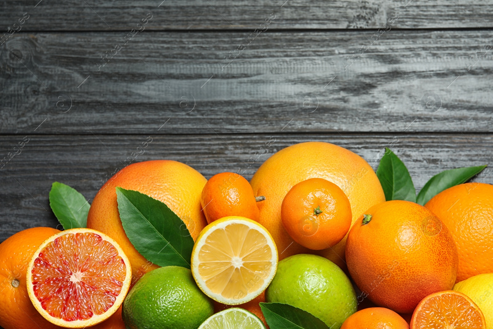 Photo of Flat lay composition with different citrus fruits and space for text on wooden background