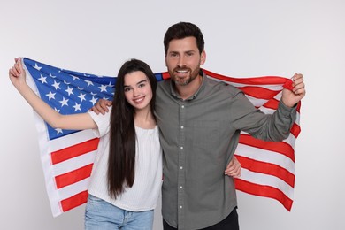 Photo of 4th of July - Independence Day of USA. Happy father and his daughter with American flag on white background