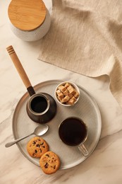 Tray with glass cup of coffee, sugar, cookies and turkish pot on white marble table, flat lay