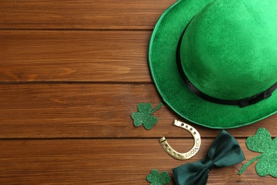 Photo of Flat lay composition with leprechaun hat on wooden table, space for text. St Patrick's Day celebration