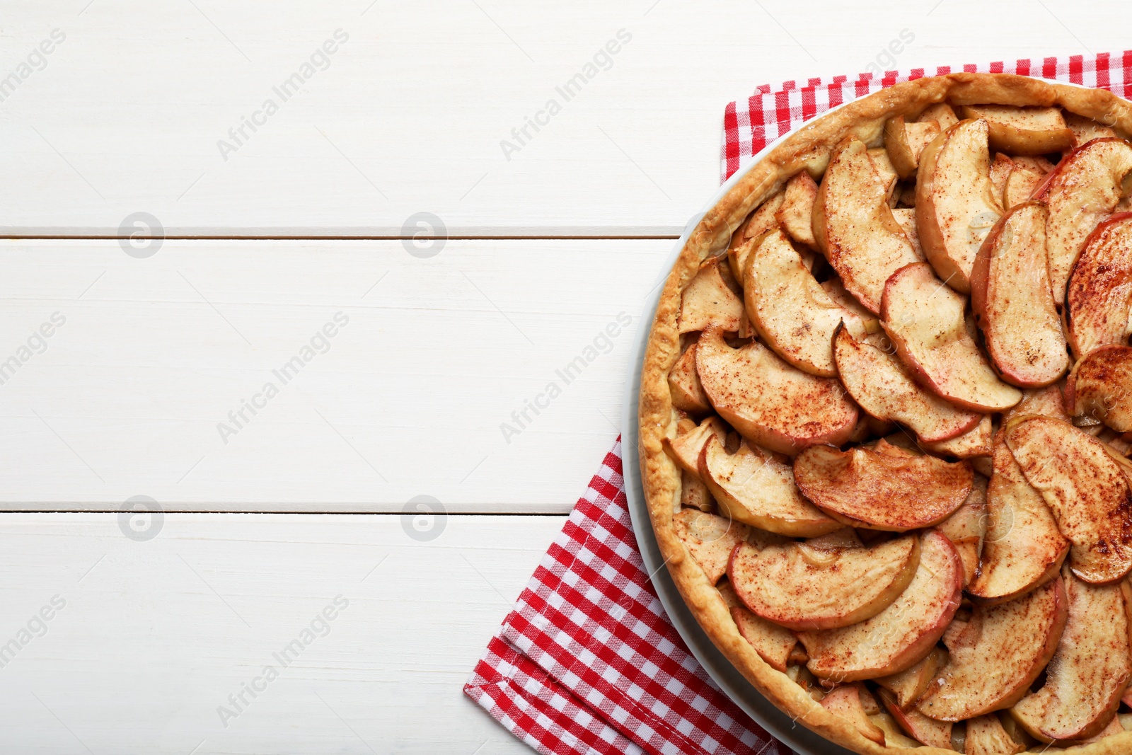 Photo of Delicious apple pie on white wooden table, top view. Space for text