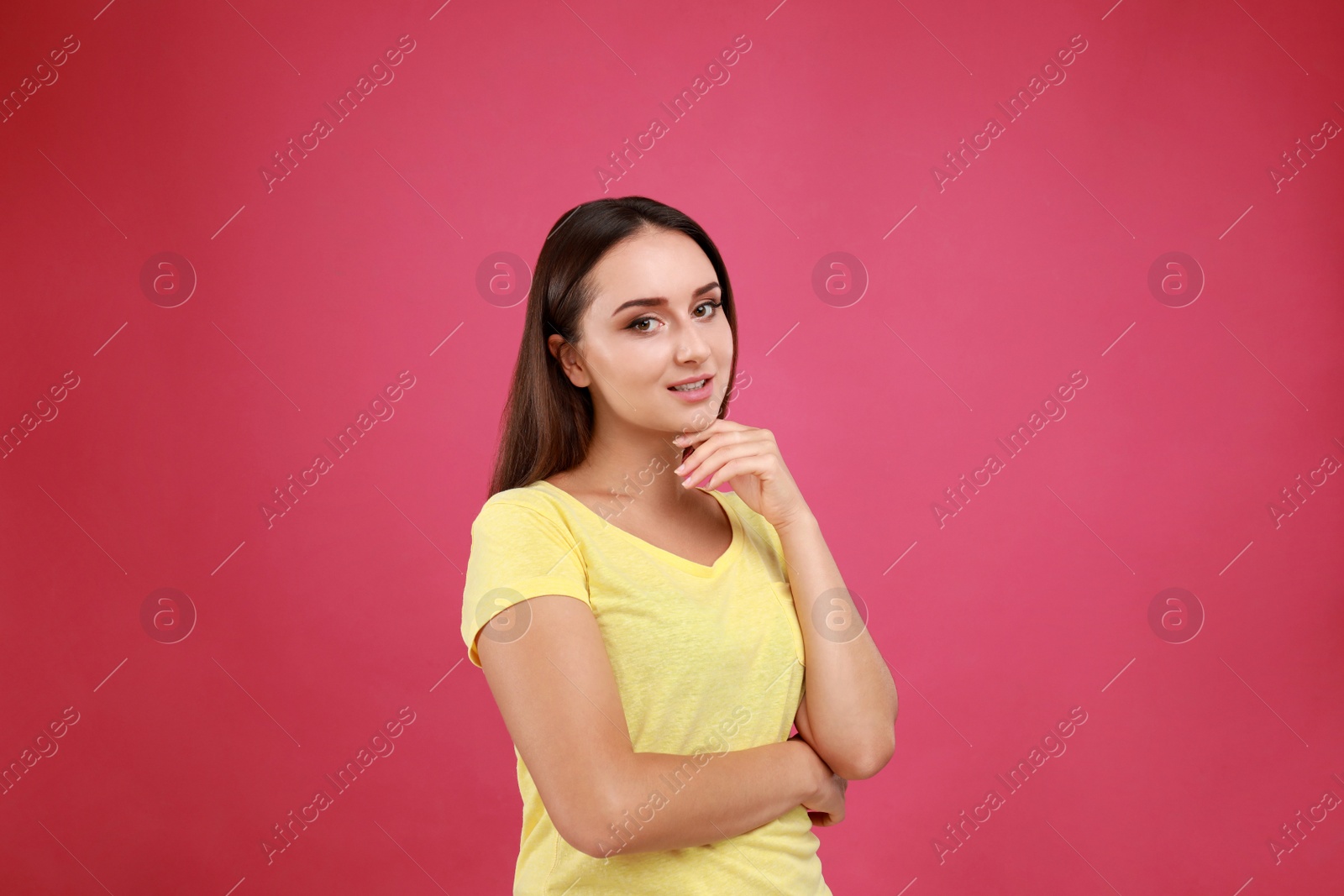 Photo of Beautiful young woman in casual outfit on crimson background