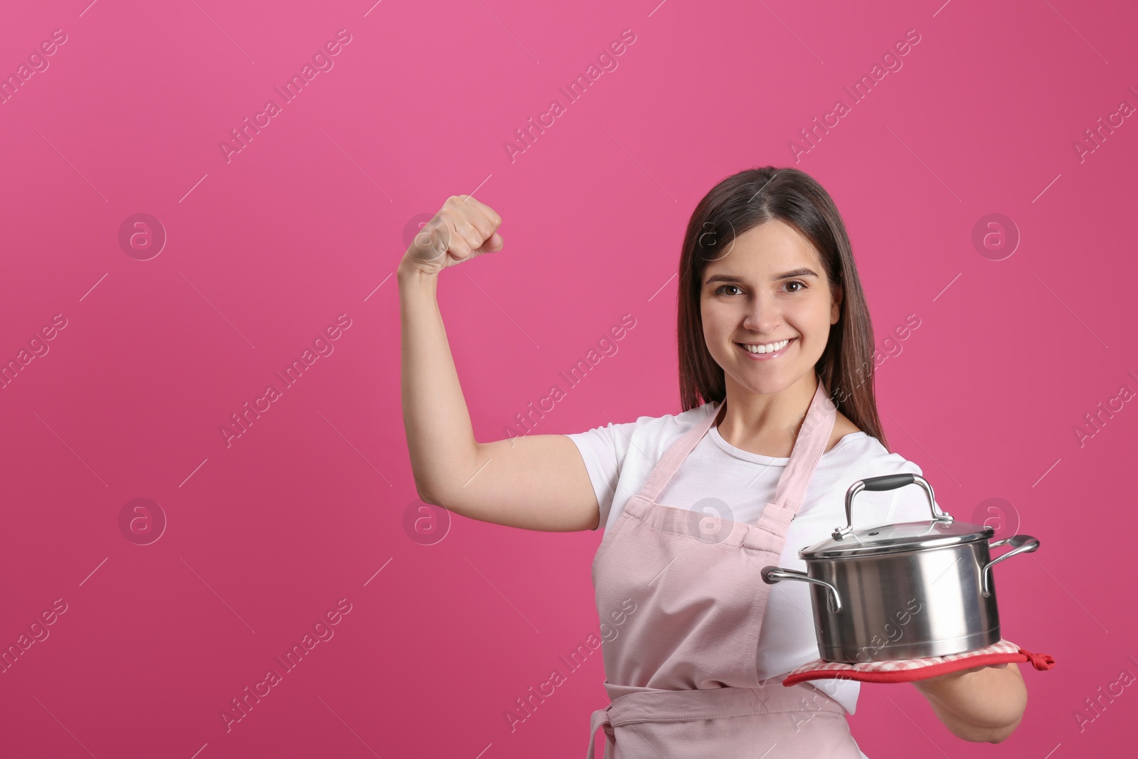 Photo of Happy young woman with cooking pot on pink background. Space for text