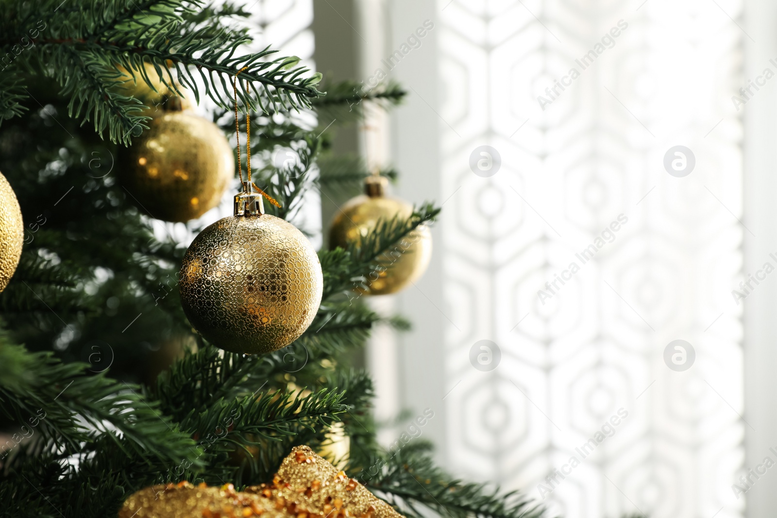 Photo of Beautifully decorated Christmas tree in room, closeup. Space for text