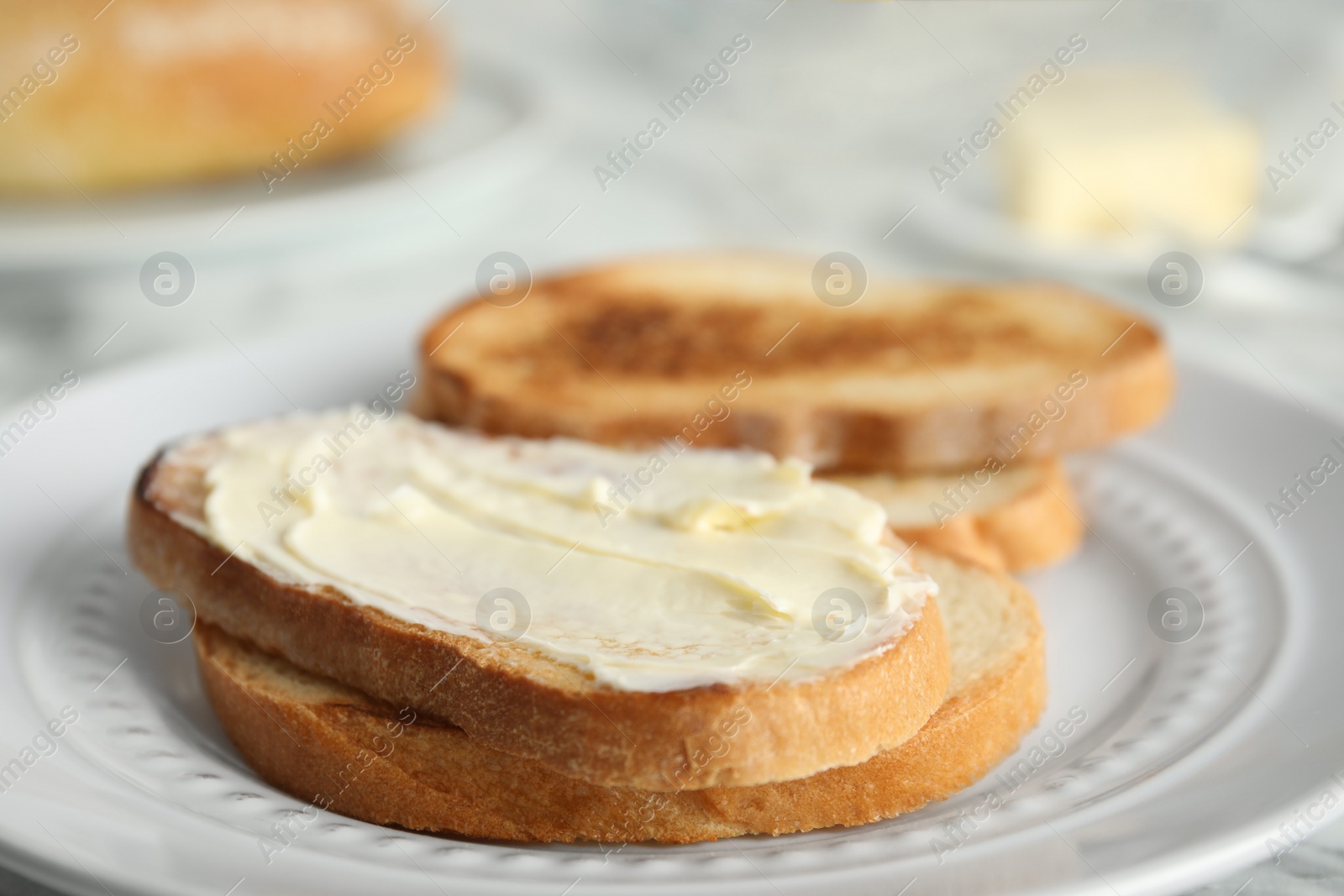 Photo of Tasty bread with butter on plate, closeup