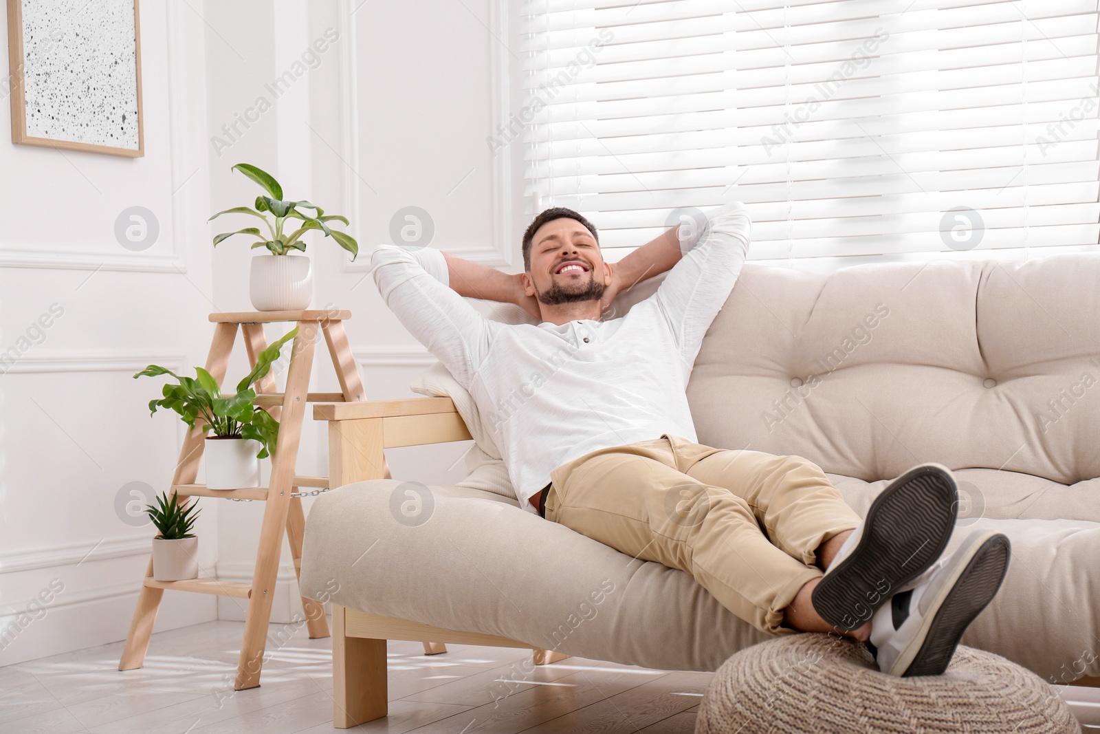 Photo of Handsome man relaxing on sofa at home