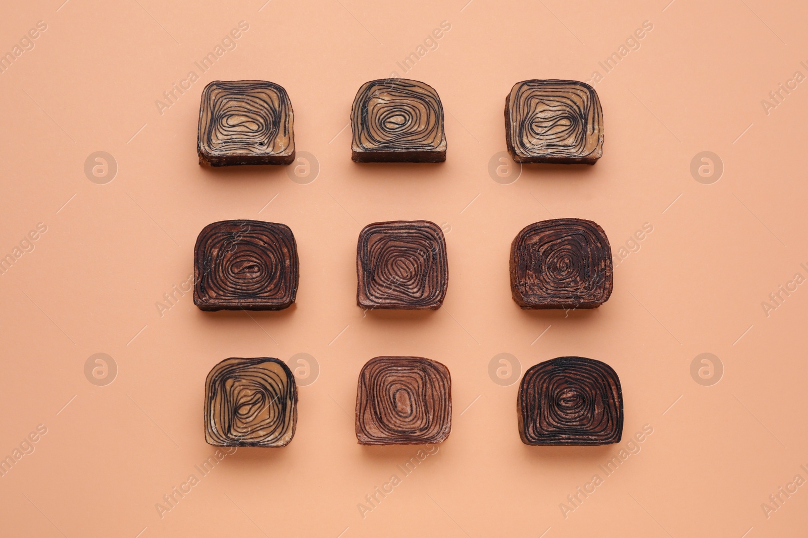 Photo of Different tasty chocolate candies on beige background, flat lay