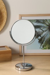 Photo of Mirror and picture on wooden table in room
