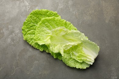 Photo of Fresh Chinese cabbage leaves on gray textured table, top view