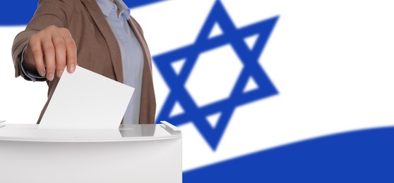 Image of Woman putting her vote into ballot box against national flag of Israel, closeup. Banner design with space for text