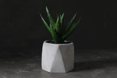 Photo of Artificial plant in flower pot on grey stone table