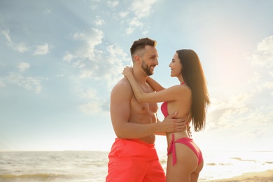 Happy young couple on beach on sunny day