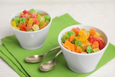 Photo of Spoons and bowls with delicious candied fruits on table