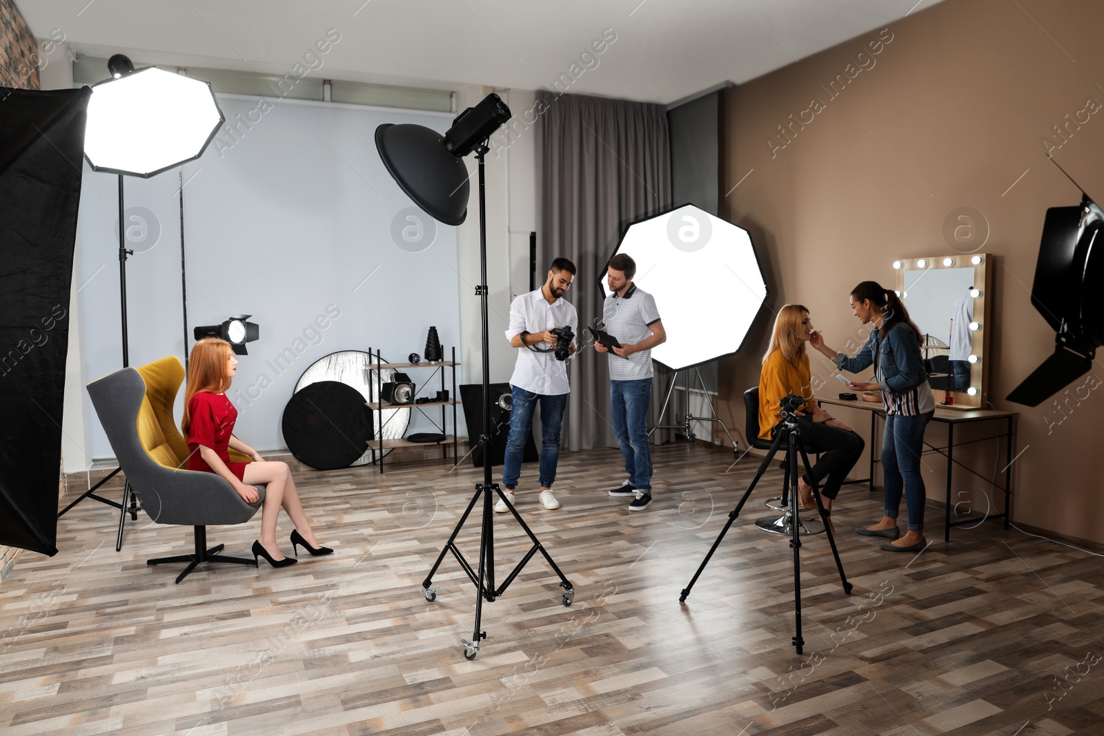 Photo of Photo studio with professional equipment and team of workers