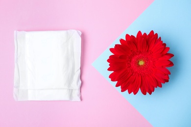 Flat lay composition with menstrual pad and gerbera flower on color background. Gynecological care