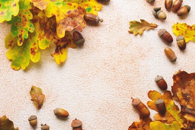 Frame of autumn leaves and acorns on color background, flat lay. Space for text